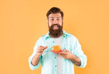 man in tuxedo bow tie with coffee cup. gentleman in formalwear smelling coffee on black background.