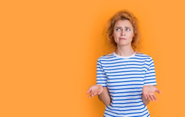 puzzled redhead woman portrait isolated on yellow background. portrait of young redhead woman in studio. adult redhead woman portrait.