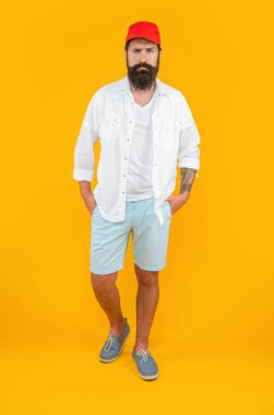 Beyaz şapkalı şık bir adamın görüntüsü. Sarı üzerine izole edilmiş şık beyaz adam. Stüdyoda şık bir beyaz adam var. Arka planda şık beyaz adam.