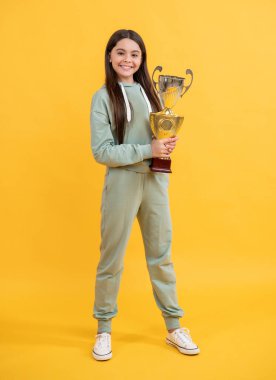 Genç kız şampiyon. Spor başarısı ve zafer. Genç kız şampiyonluk kupasını tutuyor. Sporda kazanan kız. Başarılı bir gençlik sporu ve çocukluğu. Gerçek şampiyon olmak. Başarıyı kutlamak. Başarının tadı.