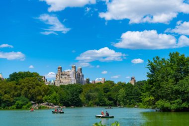 New York, ABD - 22 Temmuz 2023: New York 'ta Manhattan' ın göl ve bina manzaralı Central Park. Teknedeki insanlar.