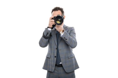 Gazeteci, beyazın üstünde tek başına fotoğraf çekiyor. Paparazzi fotoğrafçı. İş adamı fotoğraf makinesini tutar. Takım elbiseli foto muhabiri. Kameralı iş fotoğrafçısı. basın fotoğrafçısı.