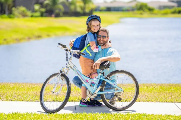 dad embracing son on biking adventure. dad and son duo pedaling through picturesque landscape. dad guiding his son first bike ride. dad and son enjoying fun bike outing. Shared biking memories.