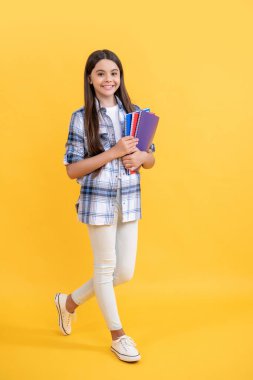 Kız çocuk eğitimi. Okula dönüyorum. Genç kızlar için okul eğitimi. Genç kız öğrenci çalışma kitaplarını tutuyor. Çocukluktan beri bilgi edinmek. Okulda öğrenme konuları. Okul yılları.