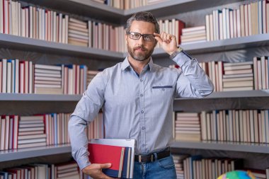 Öğretmenim sınıfta. Okul kütüphanesi kitaplarla dolu. Kitapçıda erkek öğretmen. Bilgi ve eğitim kavramı. Öğretmenler günü. Bin yıllık üniversite öğrencisi. Okulda eğitim. 1 Eylül.