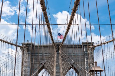 Metropolis 'teki Brooklyn Köprüsü' nün muhteşem manzarası. Brooklyn 'deki tarihi köprünün mimarisi. Amerikan mimarisi tarihi eser. Manhattan 'a giden yol. New York 'taki Brooklyn Köprüsü. Amerikan bayrağı.