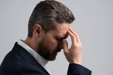 Çok çalışan bir işletme yöneticisi. Çok çalışan bir adam migren ağrısı çekiyor. Stresli, başı ağrıyan yorgun bir adam. Stres ve baş ağrısı. İş adamı kendini stresli hisseder. Stresli iş adamı. Kariyer Gerilimi.