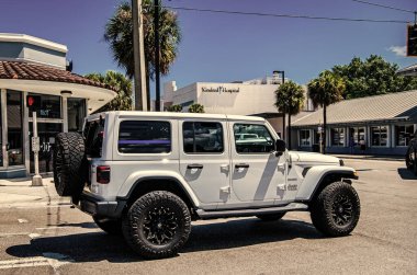Miami, Florida ABD - 25 Mart 2023: beyaz 2018 Jeep Wrangler Sınırsız Sahra arabası yolda, arka köşe manzaralı.