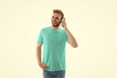 Müzik kulaklıklı neşeli adam beyazda izole edilmiş. Arka planda müzik kulaklıklı adam var. Stüdyodaki müzik kulaklıklı adam. Müzik kulaklıklı bir adamın fotoğrafı..