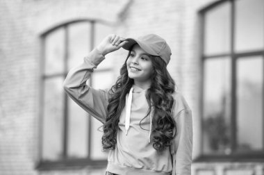 photo of happy casual teen girl childhood in cap. casual teen girl childhood outdoor. casual teen girl childhood outside. casual teen girl childhood at the street.