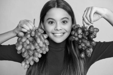 Kız gülüşü Sarı arka planda üzüm demeti.