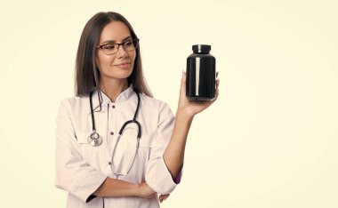 Steteskop ve ilaç takviyeli bir doktor. İlaç takviyeli doktor beyazı izole etti. Doktor ilaç takviyesi yapın. Doktor beyaz önlük giyip ilaç takviyesi alıyor..