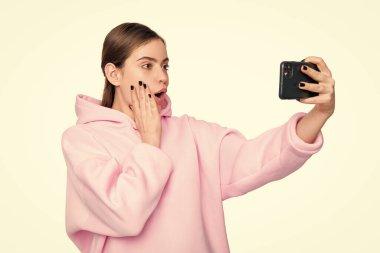 Ağzı açık, selfie çeken, elinde akıllı telefon tutan, beyaz, selfie videosu olan şaşırmış bir kız..