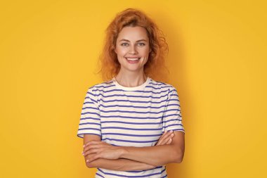 Sarı arka planda izole edilmiş neşeli kızıl saçlı kız portresi. Stüdyodaki genç kızıl saçlı kızın portresi. Yetişkin kızıl kız portresi.