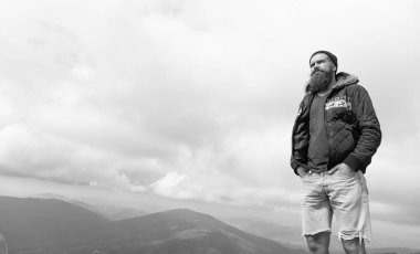 Bıyıklı beyaz bir adam, afiş. Dağda beyaz bir adamın fotoğrafı var. Açık havada beyaz bir adam. Beyaz adamın sakalı var..