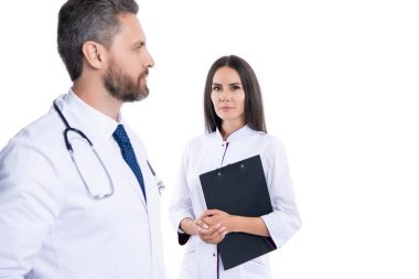 Doktor dahiliyecisi beyaz pano ile izole edilmiş. Hemşireye reçete yazan doktor. Reçeteli. İlaç ve sağlık sigortası. Hastanedeki doktor. Doktorun reçetesi var. seçici odak.