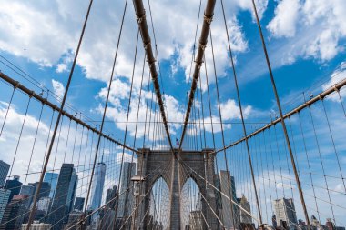 Brooklyn 'deki tarihi köprünün mimarisi. Amerikan mimarisi tarihi eser. Manhattan 'a giden yol. New York 'taki Brooklyn Köprüsü. Metropolis 'teki gökdelenlerin üzerindeki Brooklyn Köprüsü manzarası. İnanılmaz manzara.