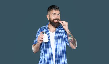 Mutlu olgun adam gri arka planda vitamin hapı alıyor..