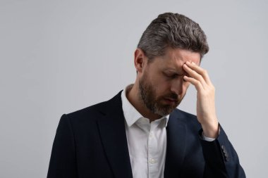 Çok çalışan bir işletme yöneticisi. Çok çalışan bir adam migren ağrısı çekiyor. Stresli, başı ağrıyan yorgun bir adam. Stres ve baş ağrısı. İş adamı kendini stresli hisseder. Stresli iş adamı.