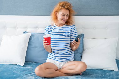 Kahveli mutlu kadının telefonda iletişimi var. Evde telefonla kadın iletişimi. Kadının evindeki telefon görüşmeleri.