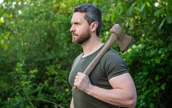 stock image caucasian man with axe. man with axe wearing shirt. man with axe outdoor. photo of man with axe.