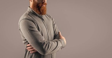 Sakallı adamın sakalı var. Gri arka planda sakallı, uzun sakallı bir adam. Sakallı adamın stüdyo fotoğrafı. sakal bakımı.