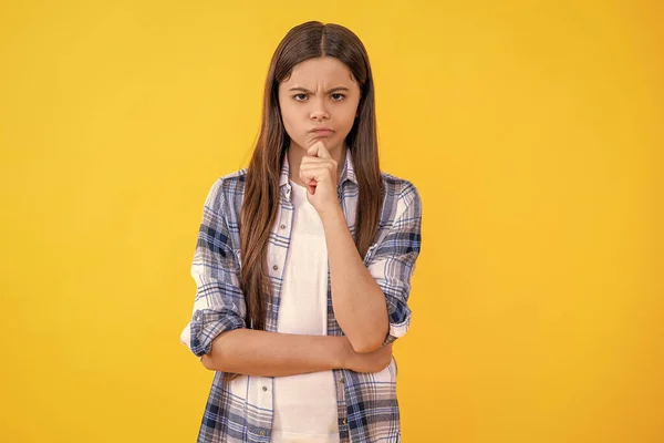 stock image sad young caucasian teen girl look at the camera isolated on yellow. teen caucasian girl wear checkered shirt in studio. caucasian teen girl in casual style. trendy teen caucasian girl on background.