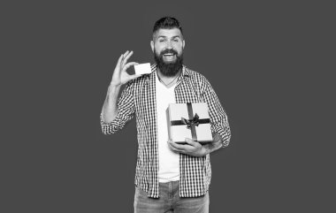 Mutlu, sakallı, hediye kutusu ve kartı olan adam..