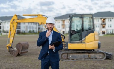 Gülümseyen inşaat müfettişi mühendis açık havada mimarlık yapıyor. İnşaat müfettişinin fotoğrafı. İnşaat müfettişi mimarlığı. İnşaat müfettişi mimarlığı