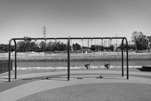 Metal dört koltuk dışarıda sallanıyor. Çocuk parkında salıncak sallıyor. Metal zincirler tarafından askıya alınmış sallanan koltuklar. Oyun parkı salıncakları. Boş salıncak.