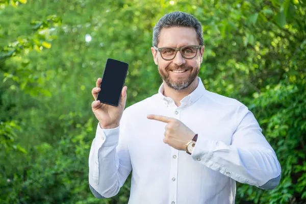 businessman with online app outdoor, point finger. businessman with online app on phone. photo of businessman with online app with copy space. businessman with online app.