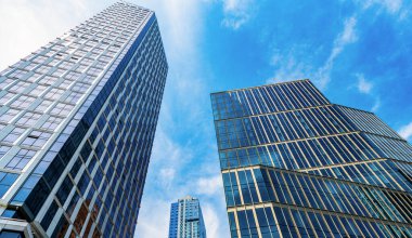 Metropolis mimarisi. Gökdelen mimarisi. Camsı yüzlü bir gökdelen. Metropolis City 'deki modern bina. Metropolis City 'de bir gökdelen. Şehir merkezinde gökdelenli bir şehir. düşük açı.