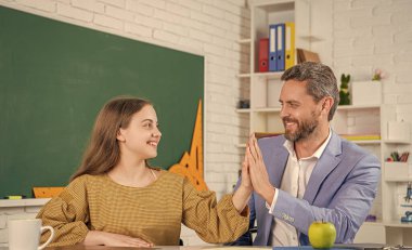 Mutlu kız, öğretmeniyle birlikte sınıfta ders çalışıyor..