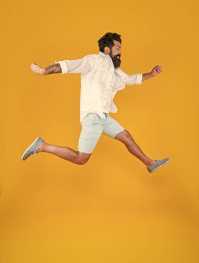 Sarı arka planda izole edilmiş yaz modası giyen mutlu sakallı adamın görüntüsü..