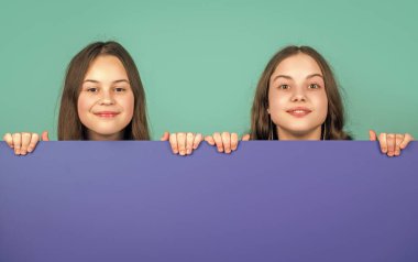 Boş mavi kağıdın arkasında reklam için fotokopi alanı olan neşeli çocuklar..