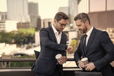 İşletme yöneticisi dışarıdaki zamanı kontrol et, kopyala alanı. Takım elbiseli bir işletme yöneticisi kahve tutuyor. İşletme Yöneticisi 'nin fotoğrafı. İşletme yöneticisi sokaklarda kontrol zamanı.