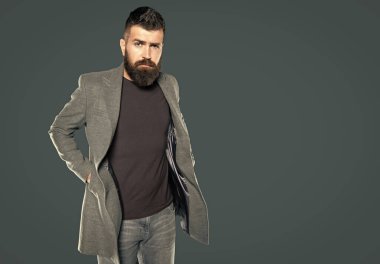Gri arka planda sıradan sakallı yetişkin bir adam..