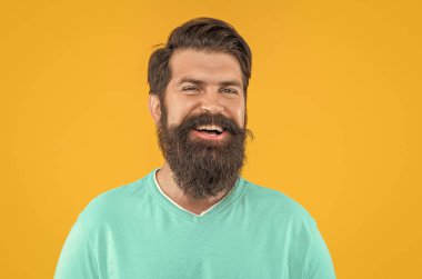 Sarıda izole edilmiş mutlu sakallı adamın portresi. Stüdyoda sakallı adamın portresi. Arka planda sakallı adamın portresi. Sakallı adamın portresi..