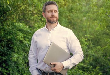 Gururlu iş adamının dışarıda online işi var. İş adamının bilgisayarında internet işi var. İş adamının fotoğrafının internette işi var. İş adamının internet işi var.