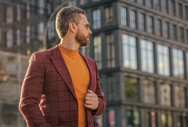 Ceketli şık adam dışarı bakıyor. Sokakta şık bir adam. Dışarıda şık bir adam var. Ceket giyen şık bir adamın fotoğrafı..
