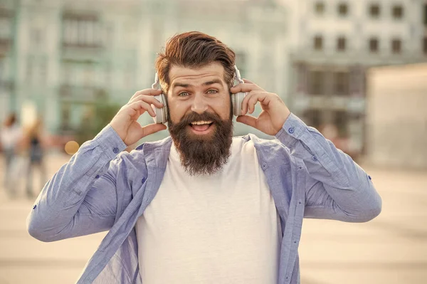 photo of cheerful man hipster in music headphones. man hipster in music headphones outdoor. man hipster in music headphones outside. man hipster in music headphones in the street.