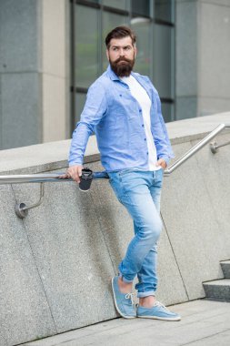 Bir adamın kahve içerken çekilmiş uzun bir fotoğrafı. Adam dışarıda kahve içiyor. Dışarıda kahve içen bir adam. Adam sokakta kahve içiyor..