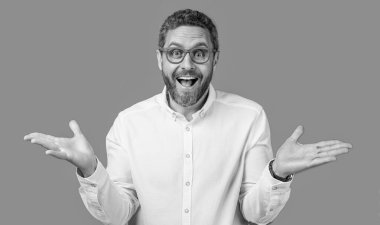 Şaşırmış adam gözlükleriyle bakıyor. Olgun bir adamın göz giysisindeki fotoğrafı. Adam mavi arka planda izole edilmiş göz giysisine bak. Olgun bir adam stüdyoda gözlük takar..