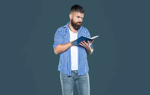 busy bearded man reading book on grey background.