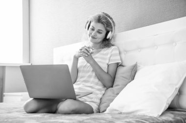 Kulaklıklı gülümseyen kadın blogcu. Blogcu kadın evde. blog yazarı kadın dizüstü bilgisayarla çalışıyor.