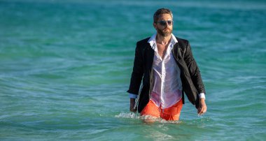 İşletme patronu hafta sonunu plajda geçirir, fotokopi çekerdi. İş adamı takım elbiseleri sahilde rahatlar. Resmi olarak dizüstü bilgisayarı olan iş adamı tropik plaj yakınlarında giyiniyor. Sıcak iş yazı.