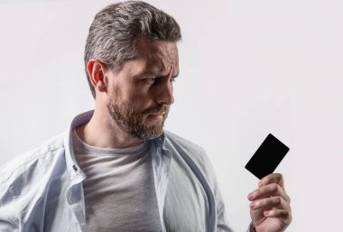 upset guy with business debit in studio. guy holding business debit. photo of guy hold business debit. guy show business debit isolated on studio background.