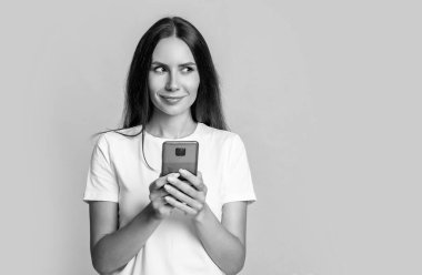 Cep telefonu stüdyosundan mesaj atan bir kadın. Akıllı telefonda cep telefonu uygulaması kullanan bir mesajcı kadın. Kadının mobil iletişimi. Cep telefonuyla sohbet ediyorlar. Telefonu olan kadın, kopyalama alanı.