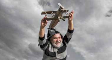 Mutlu emeklilik. Oyuncakla pozitif büyükbaba. Emekli yaşlı adam dışarıda. Emekli olan yaşlı adam gökyüzü geçmişinde.