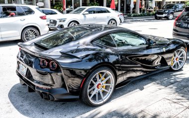 Miami Beach, Florida USA - April 15, 2021: black ferrari F12 berlinetta supercar, side corner view.